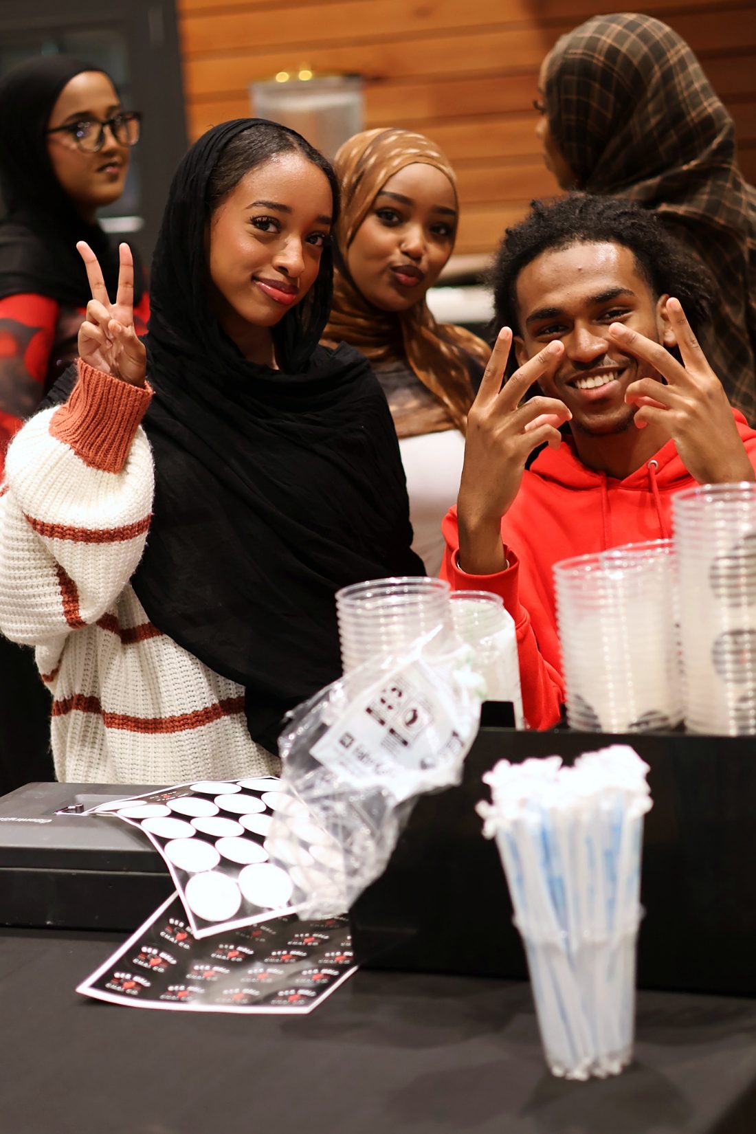 Guests smiling and posing at a vendor table during a Haflad event