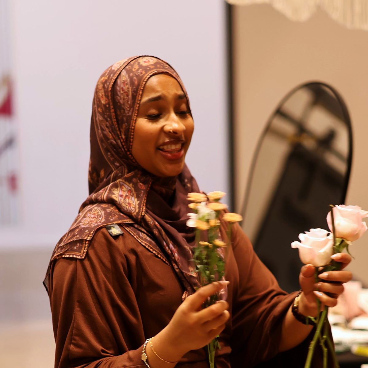 A vendor holding fresh roses at her booth